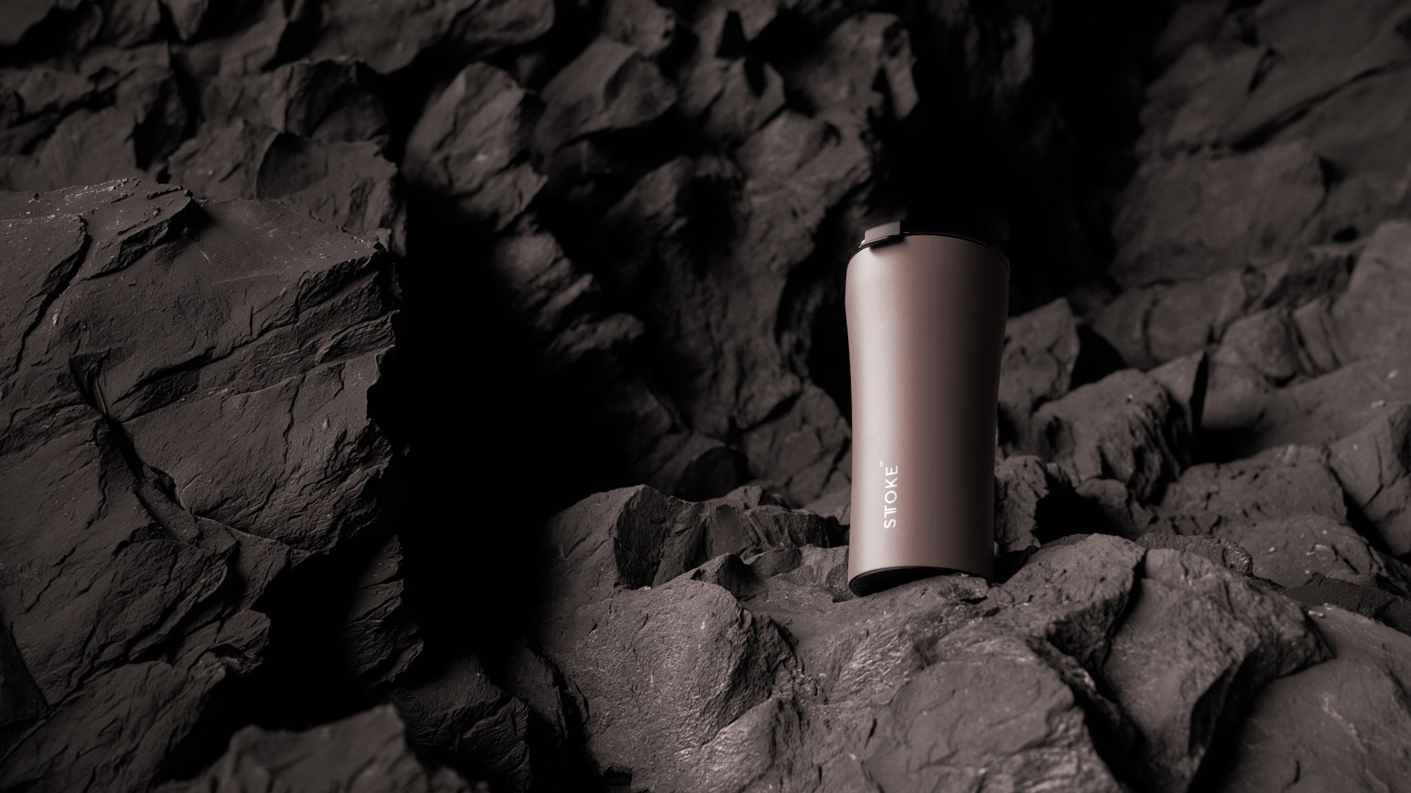 STTOKE commuter cup standing on dark rock